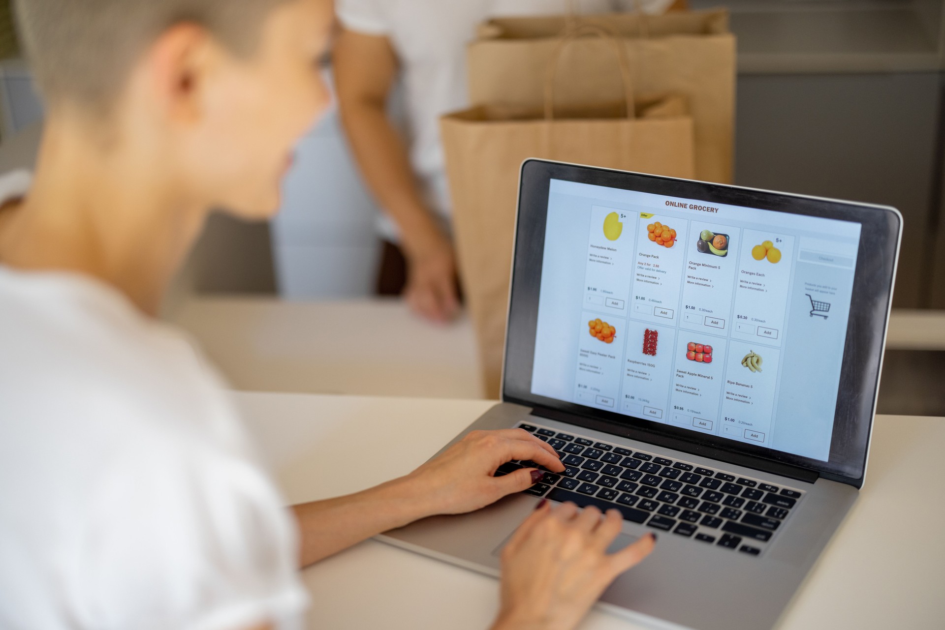 Woman choosing groceries online and man with bags